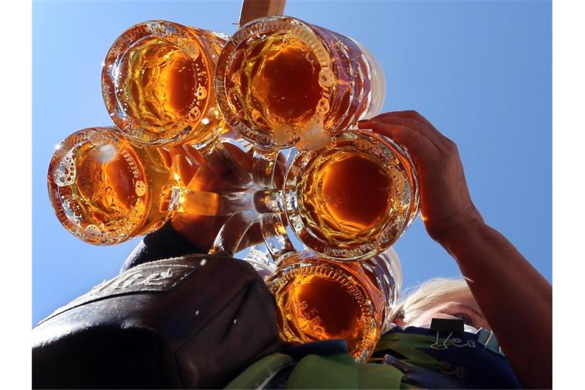 Bierbrauer holen im September auf Auftakt zum diesjährigen Oktoberfest: Eine Bedienung trägt Bier im Außenbereich eines Festzeltes. Die deutschen Brauereien haben im September einen Teil des Rückstandes zum Vorjahr wettgemacht. Foto: Karl-Josef Hildenbrand/dpa