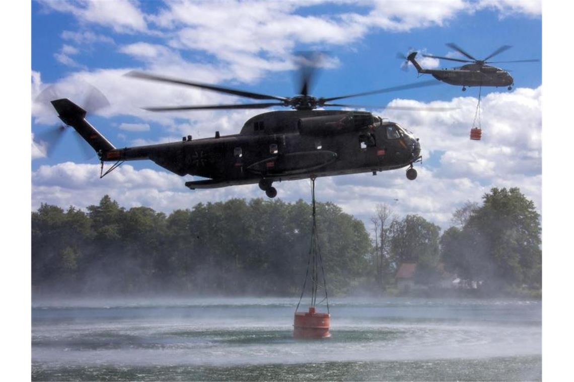 Auftanken: Hubschrauber der Bundeswehr nehmen jeweils 5000 Liter Löschwasser in einem See auf. Foto: Jens Büttner