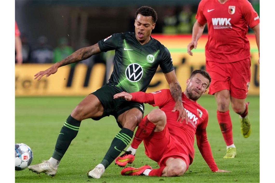 Augsburgs Daniel Baier (r) führt einen Zweikampf gegen Wolfsburgs Lukas Nmecha. Foto: Peter Steffen/dpa