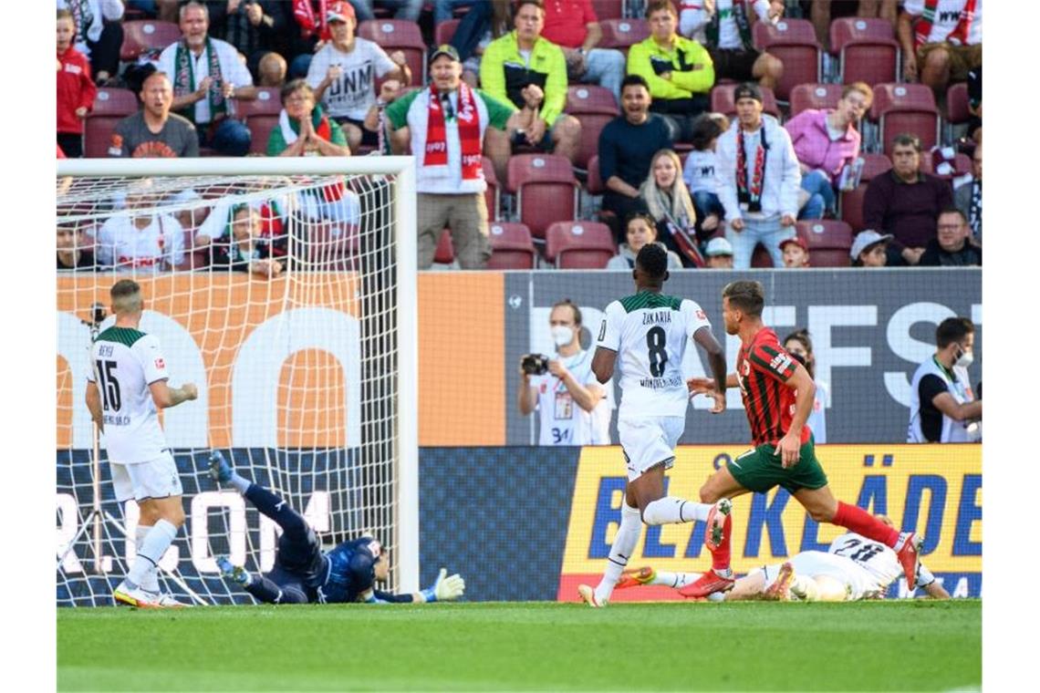 Augsburgs Florian Niederlechner (r) erzielt den 1:0-Siegtreffer für seine Mannschaft. Foto: Matthias Balk/dpa