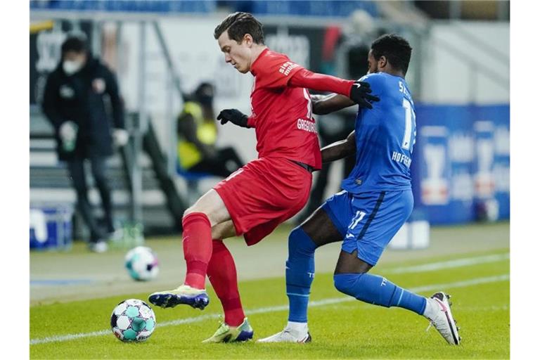 Augsburgs Michael Gregoritsch und Hoffenheims Ryan Sessegnon (l-r.) im Zweikampf um den Ball. Foto: Uwe Anspach/dpa