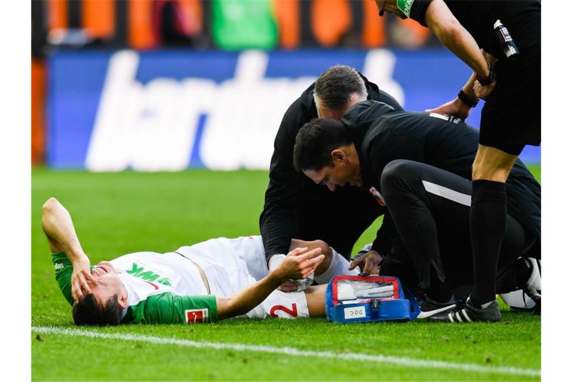 Augsburgs Stephan Lichtsteiner liegt beim Spiel gegen den SC Freiburg verletzt auf dem Boden. Foto: Tom Weller/dpa