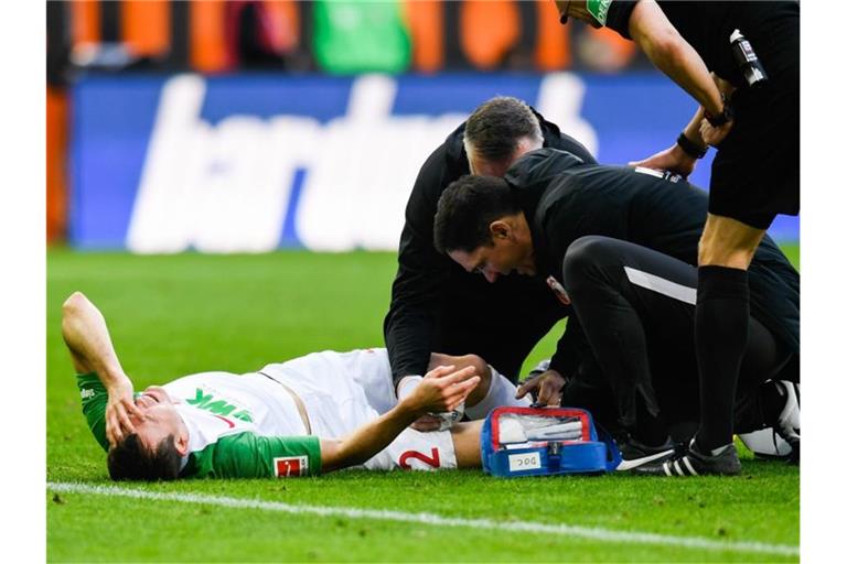 Augsburgs Stephan Lichtsteiner liegt beim Spiel gegen den SC Freiburg verletzt auf dem Boden. Foto: Tom Weller/dpa