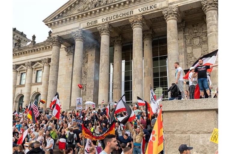 August 2020: Teilnehmer einer Kundgebung gegen die Corona-Maßnahmen auf den Stufen zum Reichstagsgebäude. Foto: Achille Abboud/NurPhoto/dpa