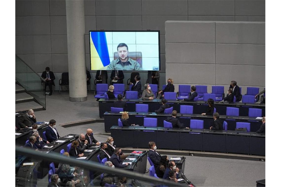 Aus dem Kriegsgebiet wird der ukrainische Präsident Wolodymyr Selenskyj per Video ins Parlament zugeschaltet. Foto: Michael Kappeler/dpa