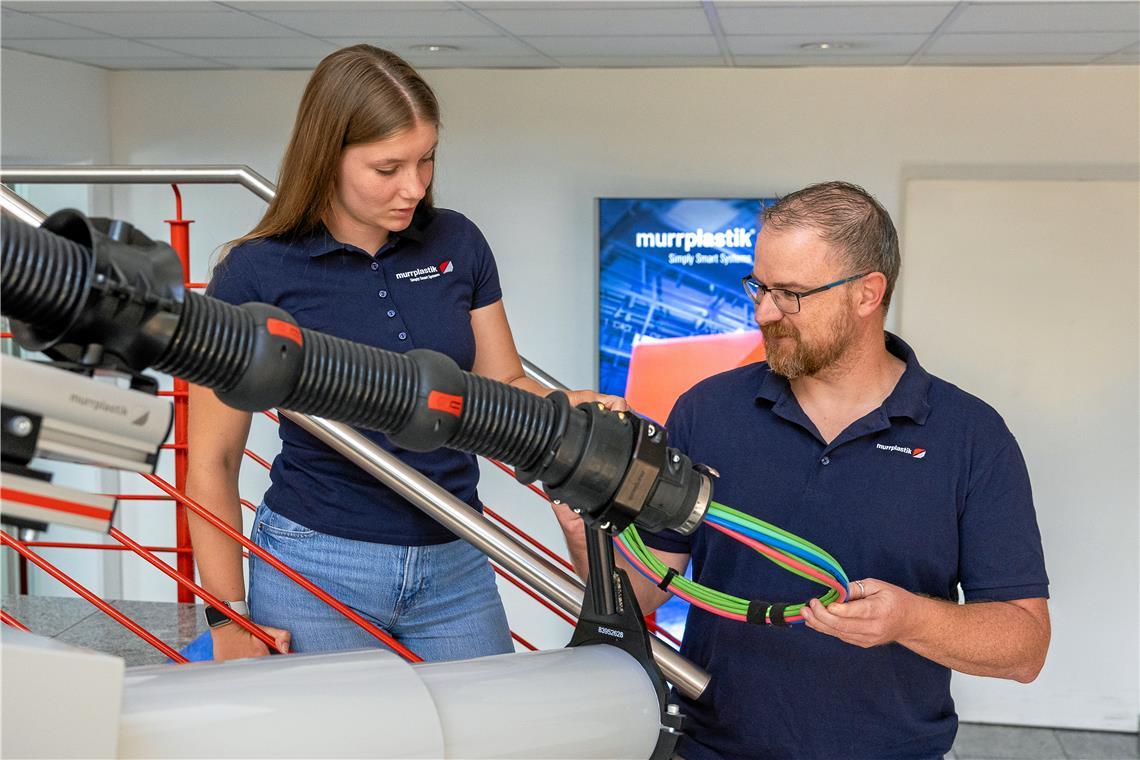 Noch viele Ausbildungsplätze unbesetzt Ausbildungsleiter Kristian Mertlik erklärt Jule Baumann das Kabelführungssystem bei einem Industrieroboter. Die junge Frau macht bei Murrplastik in Oppenweiler eine Ausbildung zur Industriekauffrau. Foto: Alexander Becher