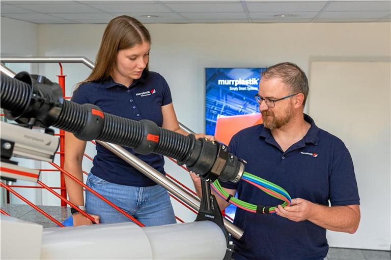 Ausbildungsleiter Kristian Mertlik erklärt Jule Baumann das Kabelführungssystem bei einem Industrieroboter. Die junge Frau macht bei Murrplastik in Oppenweiler eine Ausbildung zur Industriekauffrau. Foto: Alexander Becher