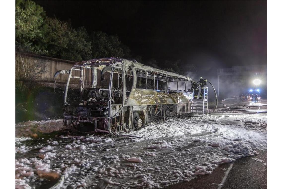 Ausgebrannt steht das Wrack eines Reisebusses auf der Autobahn A8. Foto: Aaron Klewe/Einsatz-Report24