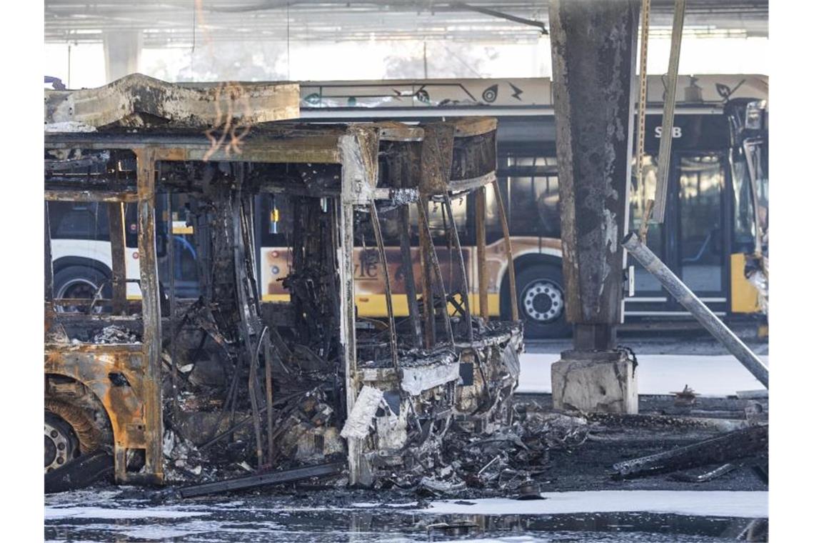 Ausgebrannte Busse stehen nach Löscharbeiten in einem Busdepot. Foto: Tom Weller/dpa/Archivbild
