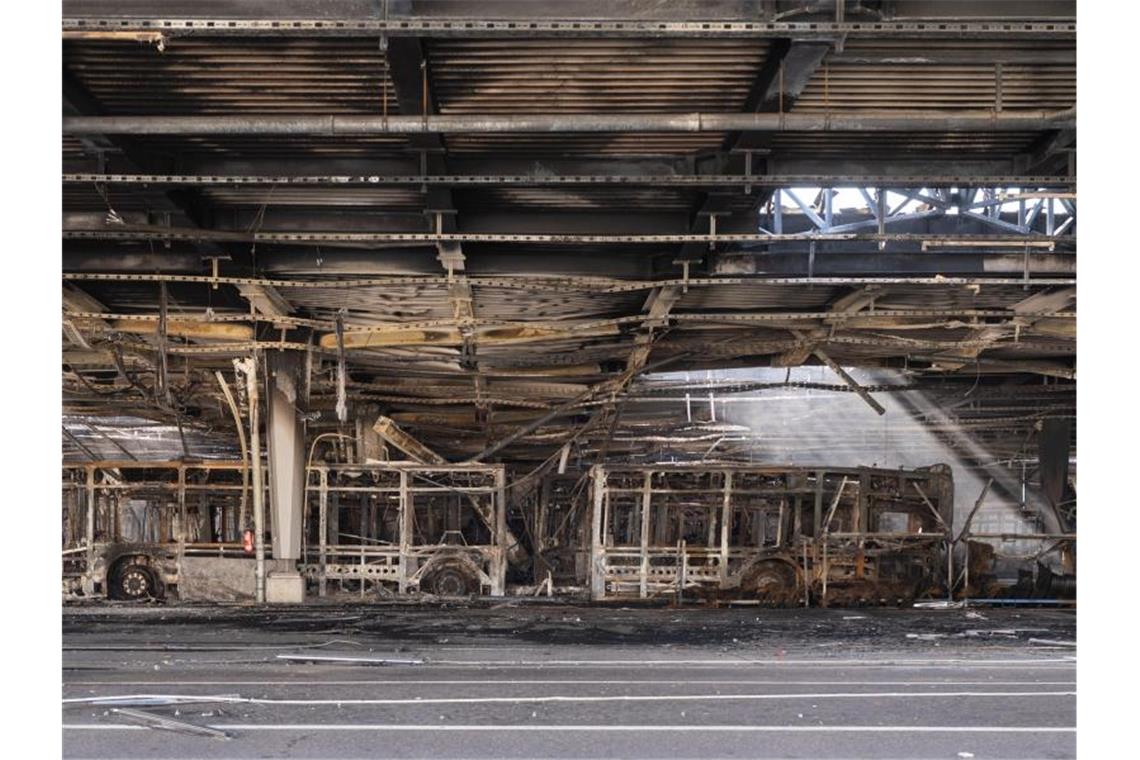 Ausgebrannte Omnibusse stehen in einem Busdepot. Foto: Marijan Murat/dpa/Archivbild