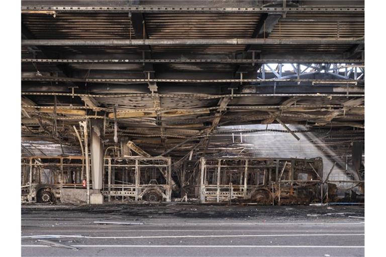Ausgebrannte Omnibusse stehen in einem Busdepot. Foto: Marijan Murat/dpa/Archivbild
