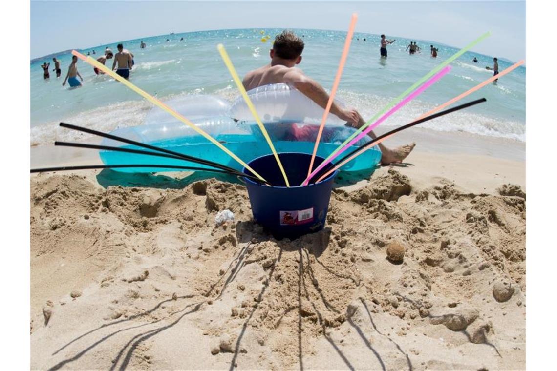 Ausgetrunken: Ein Eimer mit Strohhalmen am Strand von Arenal auf Mallorca. Foto: Julian Stratenschulte/dpa