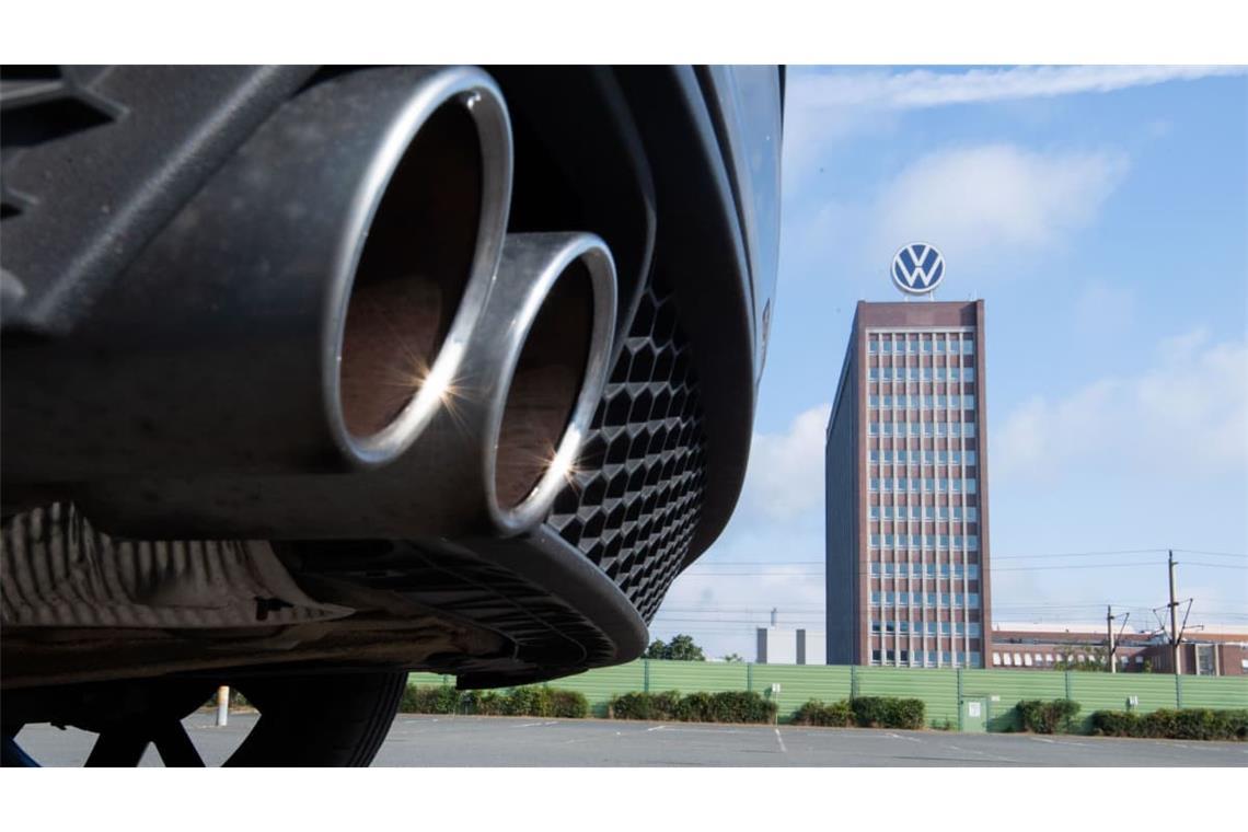 Auspuffrohre eines Volkswagen, fotografiert mit dem Markenhochhaus am VW-Werk Wolfsburg im Hintergrund. (Archivfoto)