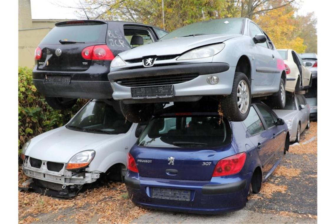 Ausrangierte Autos vor dem Gelände eines Schrottplatzes. Niedersachsens Ministerpräsident Weil will eine neue Abwrackprämie für die Autoindustrie. Foto: Wolfgang Kumm/dpa