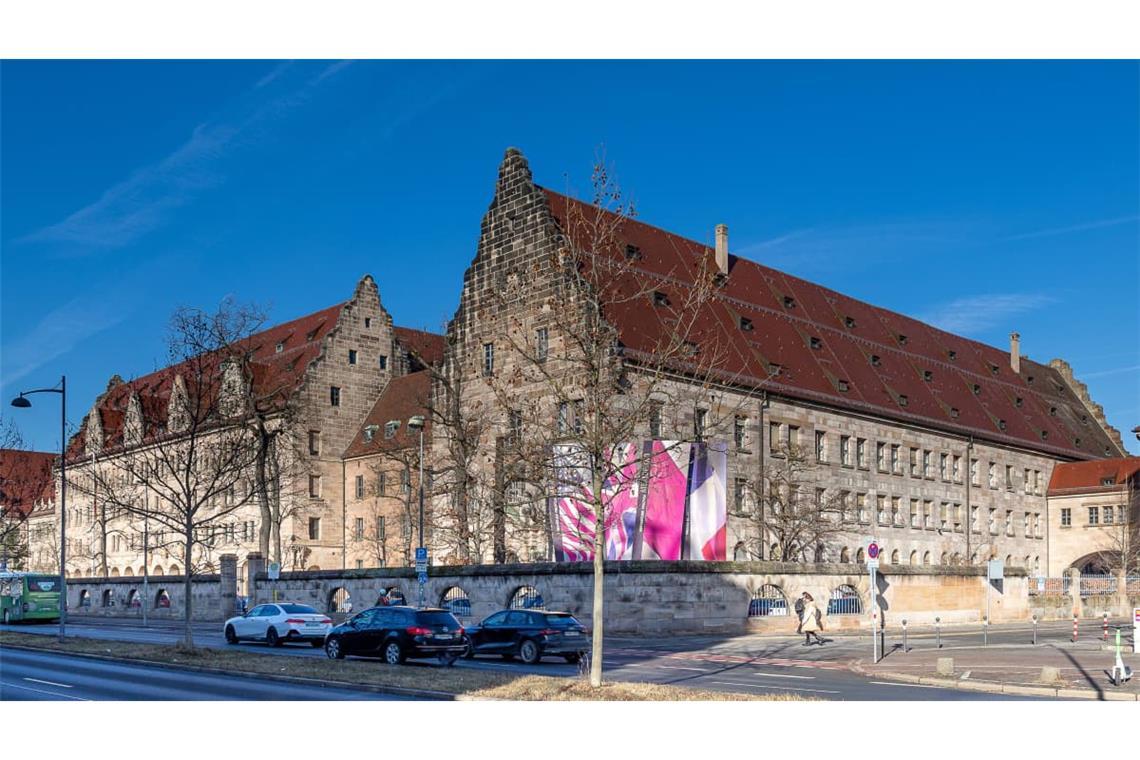 Außenansicht des historischen Justizgebäudes in der Fürther Straße in Nürnberg mit markanten Giebeln und rotem Satteldach. In dem Gebäude befinden sich unter anderem die Schwurgerichtssäle, darunter auch der Saal 600, bekannt durch die Nürnberger Prozesse. 