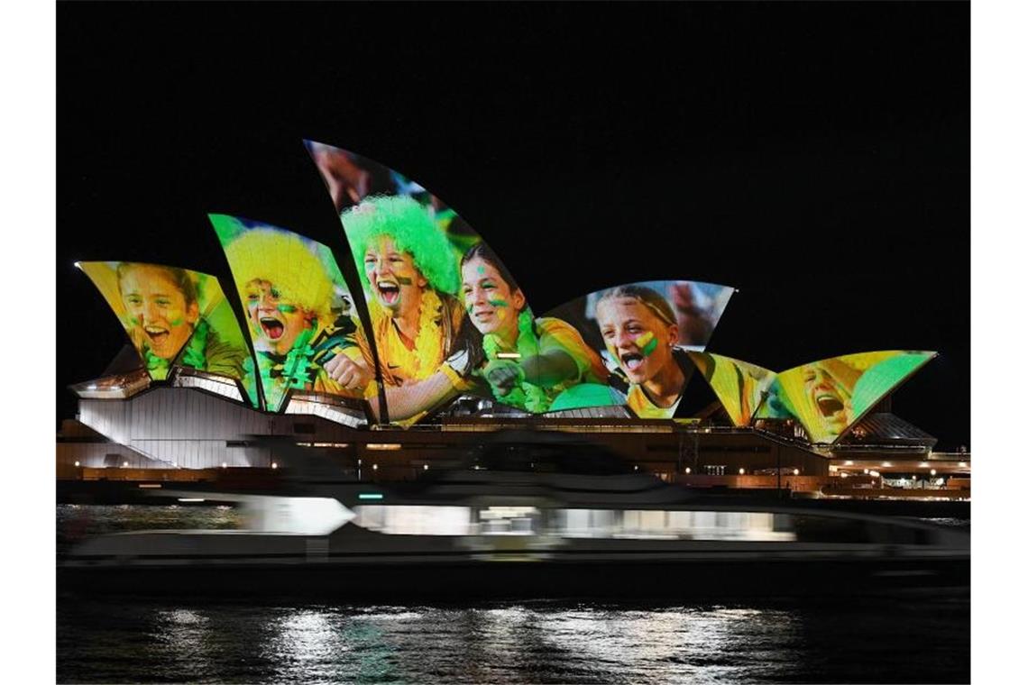 Australien und Neuseeland sind die Gastgeber der Frauenfußball-Weltmeisterschaft 2023: Das Opernhaus wird mit leuchtenden bunten Fotos von Fußball-Fans angestrahlt. Foto: Bianca De Marchi/AAP/dpa