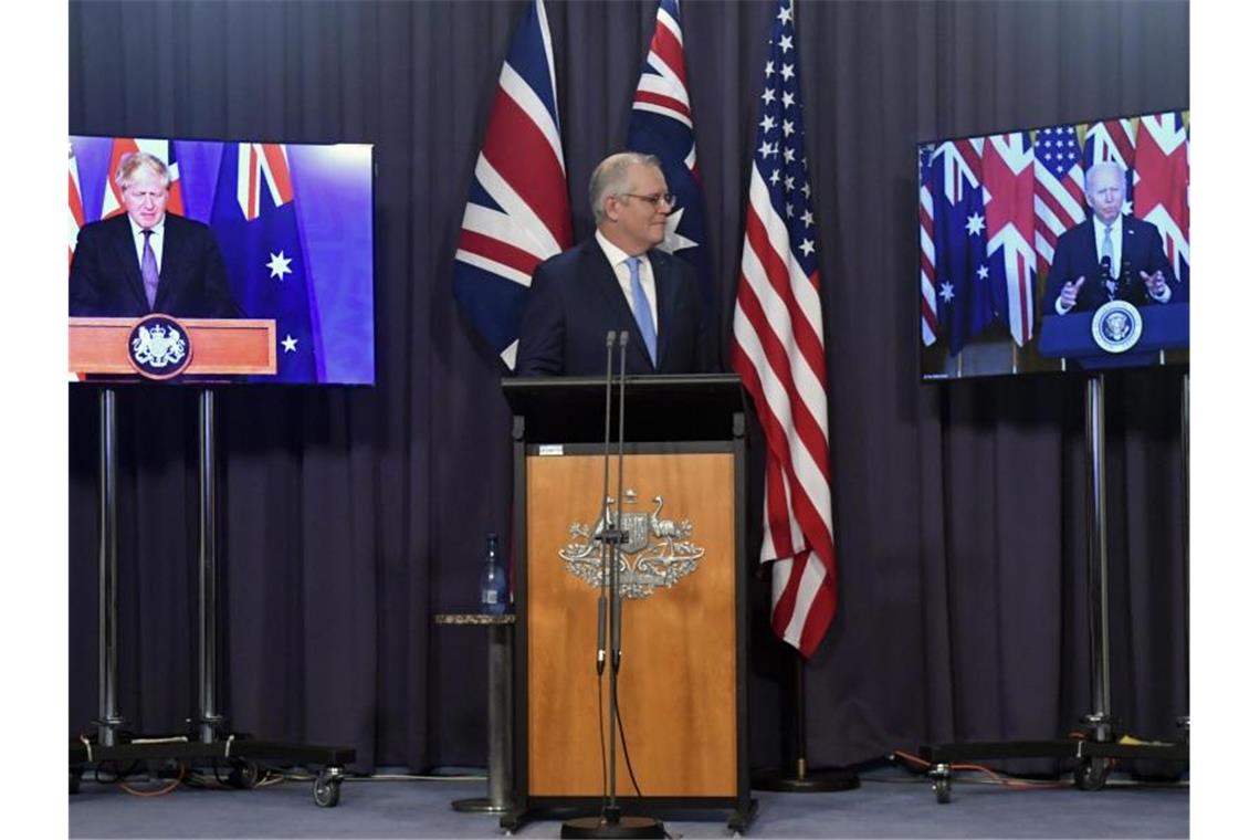 Australiens Premier Scott Morrison (M) ist in Canberra in einer Videoschalte mit seinem britischen Amtskollegen Boris Johnson (l) und US-Präsident Joe Biden verbunden. Foto: Mick Tsikas/AAP via AP/dpa