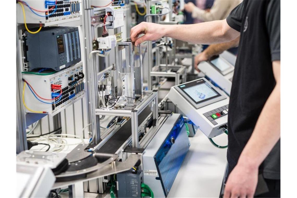 Auszubildende arbeiten im Daimler-Ausbildungszentrum in einem Industrie-4.0-Labor an einem Modell, das eine moderne Automobilproduktionsstraße nachempfindet. Foto: Christoph Schmidt/dpa