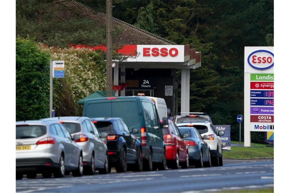 Autofahrer stehen vor einer Tankstelle in Ashford Schlange, um zu tanken. Foto: Gareth Fuller/PA/dpa