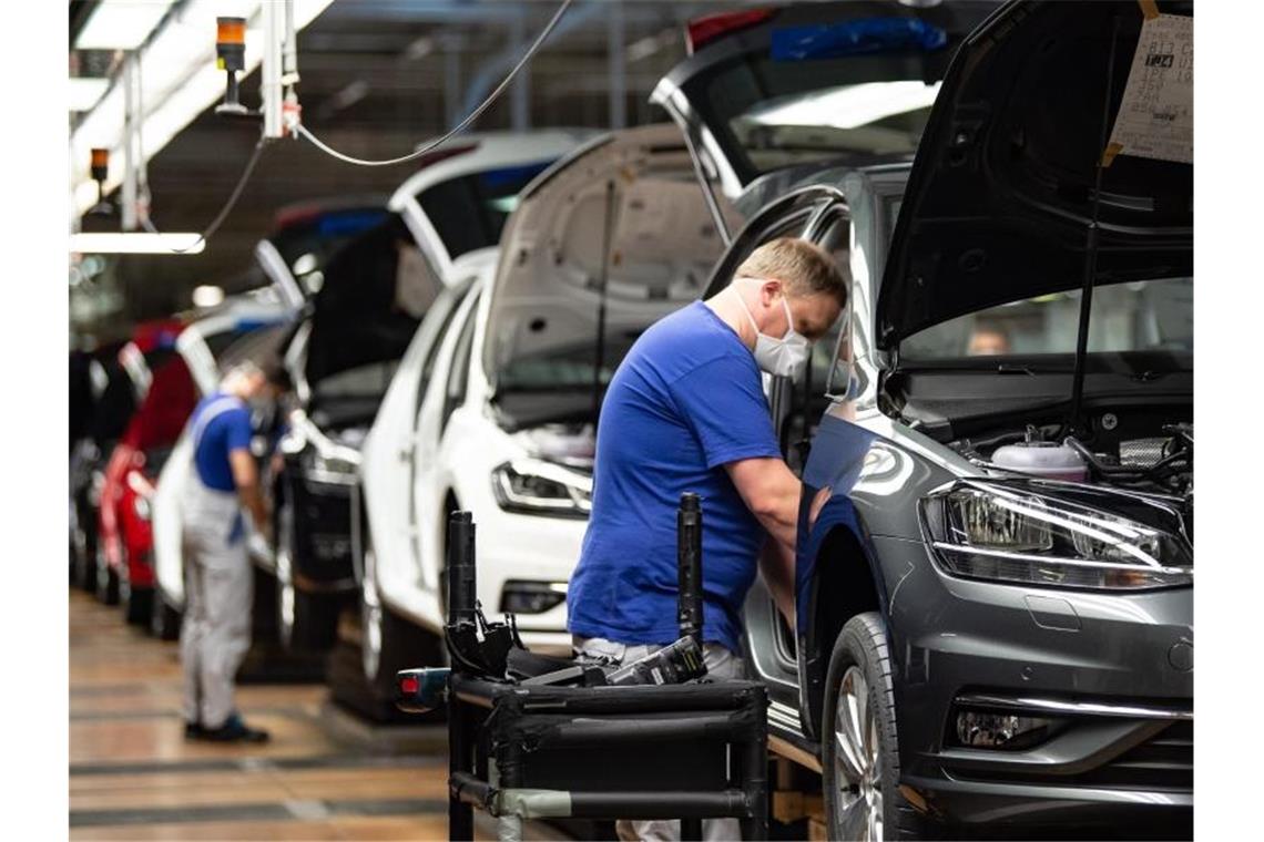 Autoproduktion mit Mund- und Nasenschutz. Die Branche fordert höhere Kaufprämien, um die eingebrochene Nachfrage anzukurbeln. Foto: Swen Pförtner/dpa