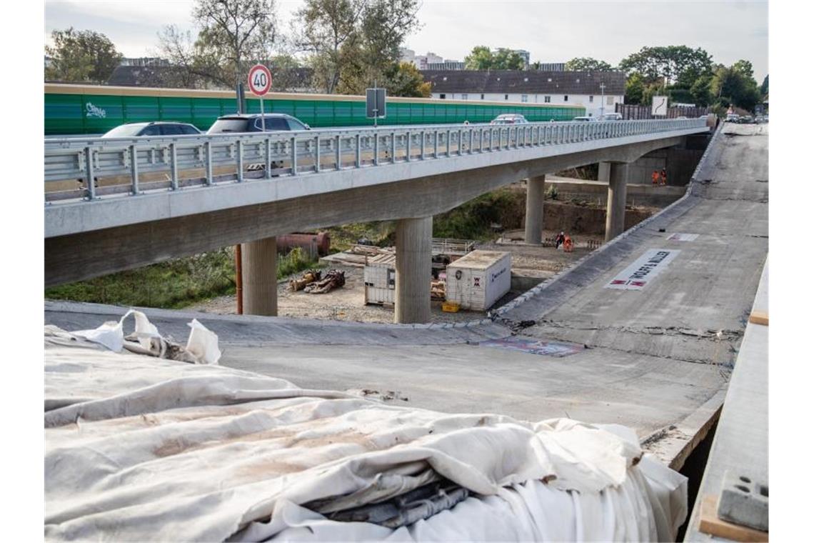Teil der Gumpenbachbrücke in Kornwestheim gesprengt Autos fahren an einem Teil der Gumpenbachbrücke vorbei, der kurz zuvor kontrolliert gesprengt wurde. Foto: Christoph Schmidt/dpa