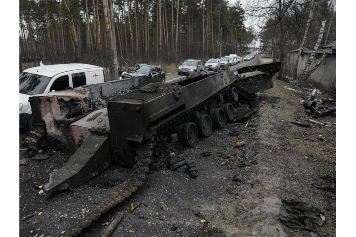 Gas-Importstopp: Ukraine erhöht Druck auf Deutschland Autos fahren an einem zerstörten russischen Panzer in der Nähe von Irpin am Stadtrand von Kiew vorbei. Foto: Vadim Ghirda/AP/dpa