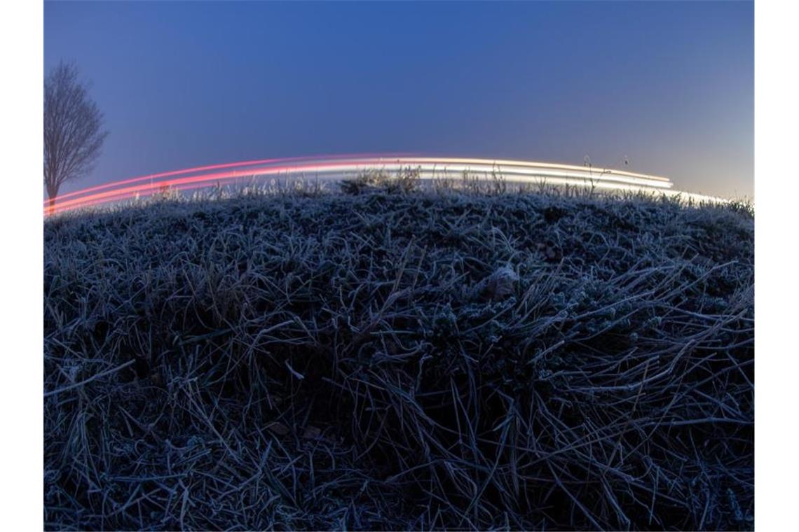 Winterdienst kämpft mit Salzlösung gegen Straßenglätte Autos fahren an einer mit Raureif bedeckten Wiese vorbei. Foto: Sebastian Gollnow/dpa/Symbolbild
