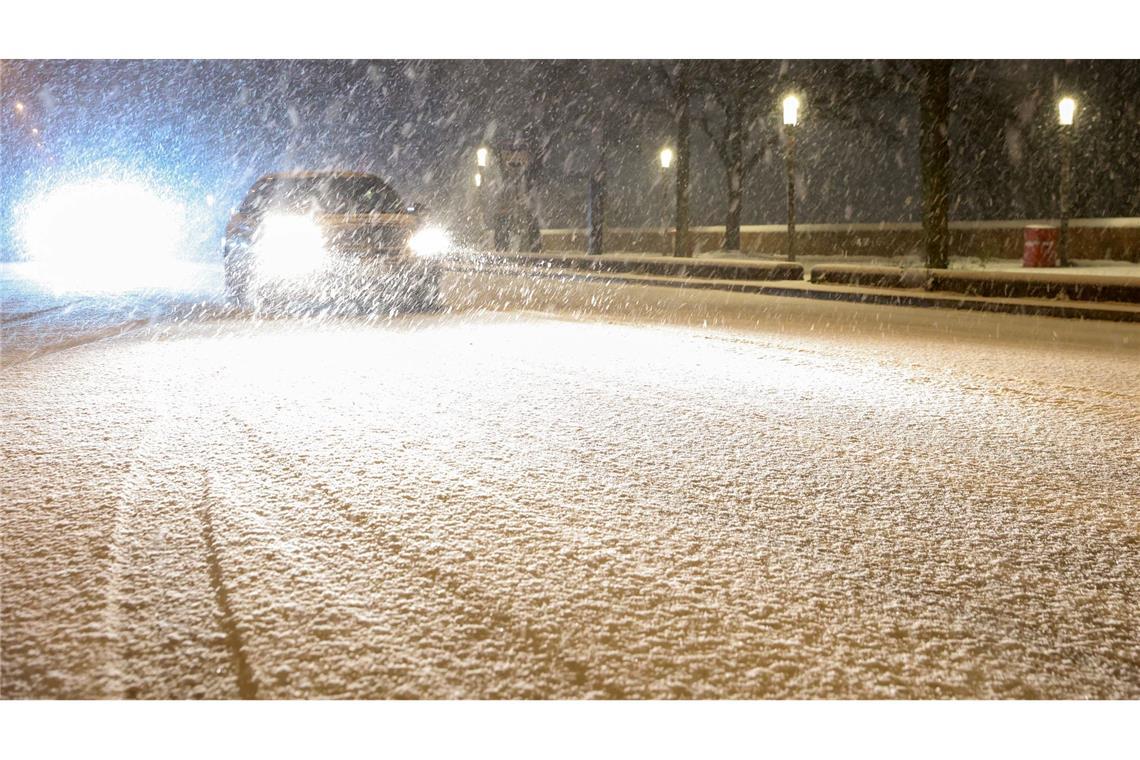 Autos fahren auf einer schneebedeckten Straße in Hamburg.