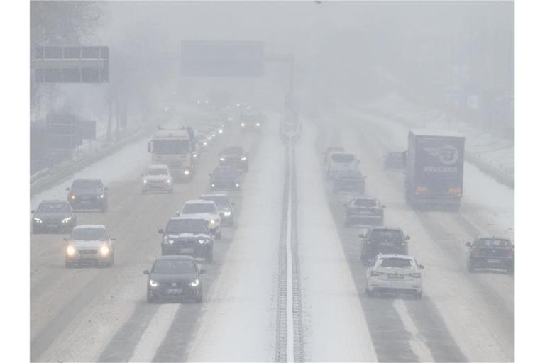 Autos fahren bei Nebel auf der mit Schnee bedeckten B10. Foto: Marijan Murat/dpa