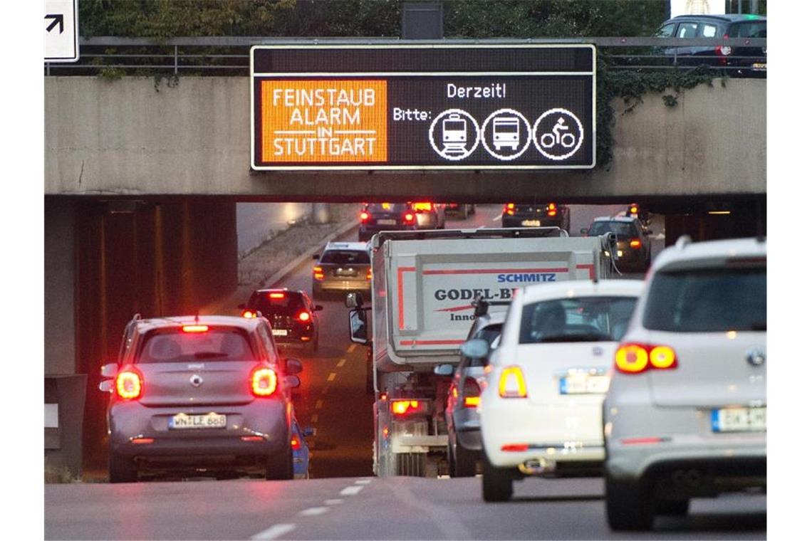 Autos fahren in der Innenstadt an einem Hinweisschild mit der Aufschrift „Feinstaubalarm“ vorbei. Foto: Bernd Weissbrod/dpa/Archiv