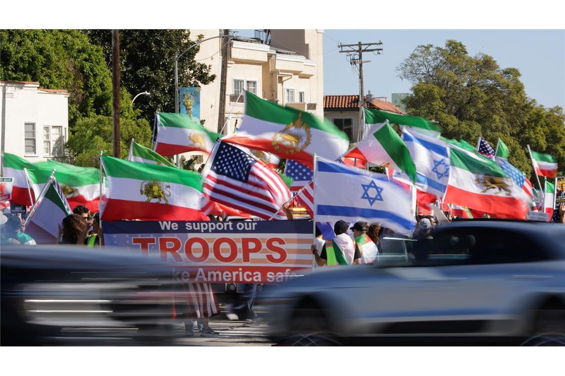 Autos fahren in Los Angeles an Demonstranten vorbei.