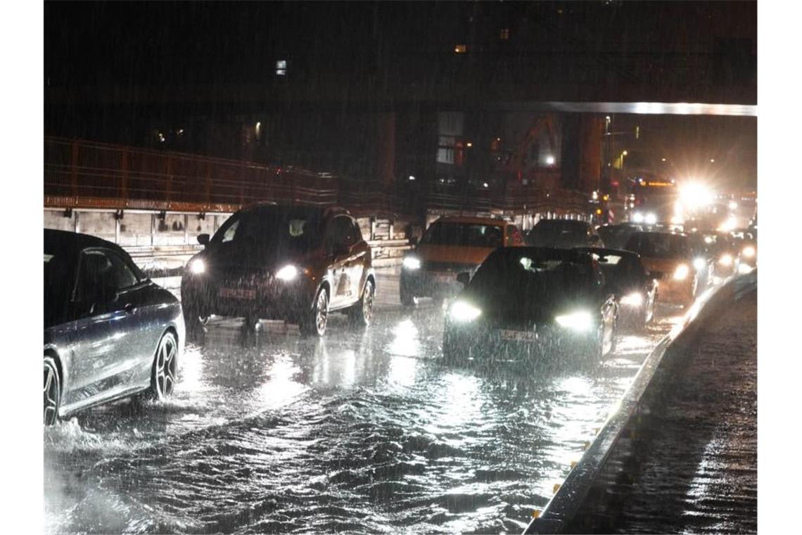 Gewitter-Wochenende: Starkregen schwemmte Autos weg Autos fahren über die überflutete Schillerstrasse am Stuttgarter Hauptbahnhof. Foto: Andreas Rosar/dpa
