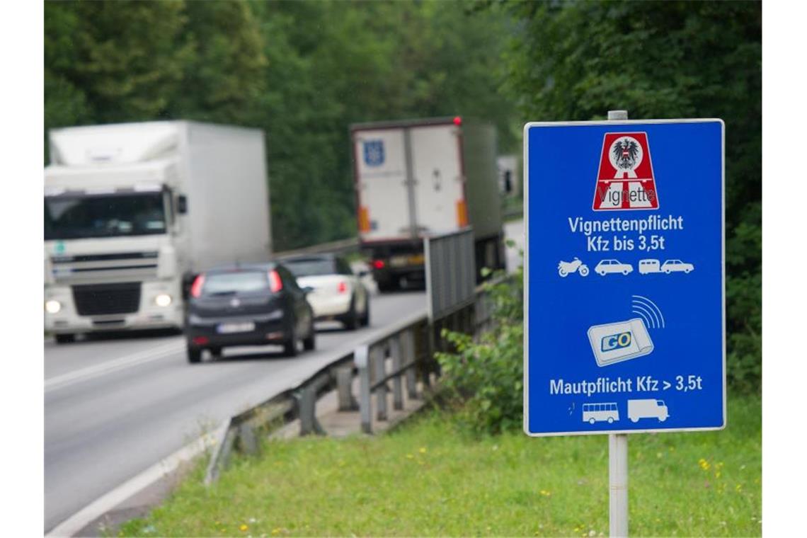 Autos und LKWs fahren an einem Hinweisschild zur Vignettenpflicht vorbei. Foto: Tobias Hase/dpa/Archivbild