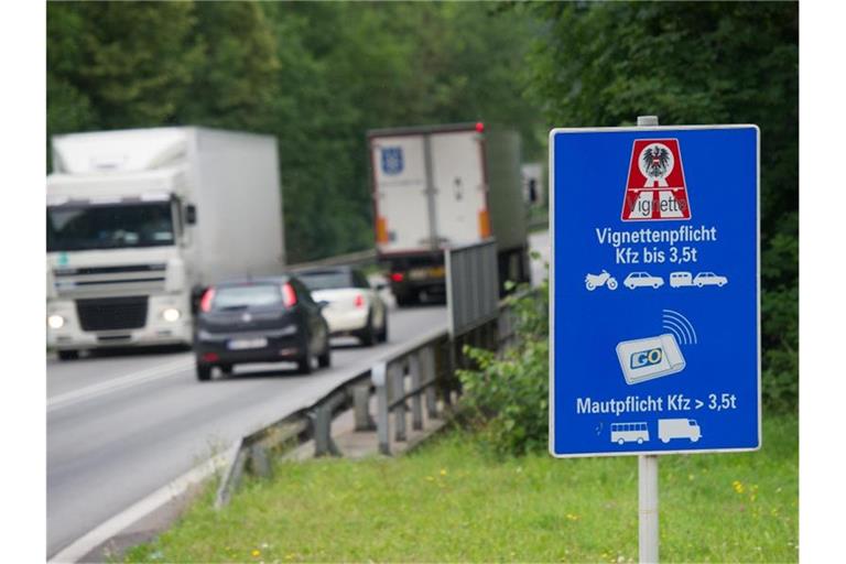 Autos und LKWs fahren an einem Hinweisschild zur Vignettenpflicht vorbei. Foto: Tobias Hase/dpa/Archivbild