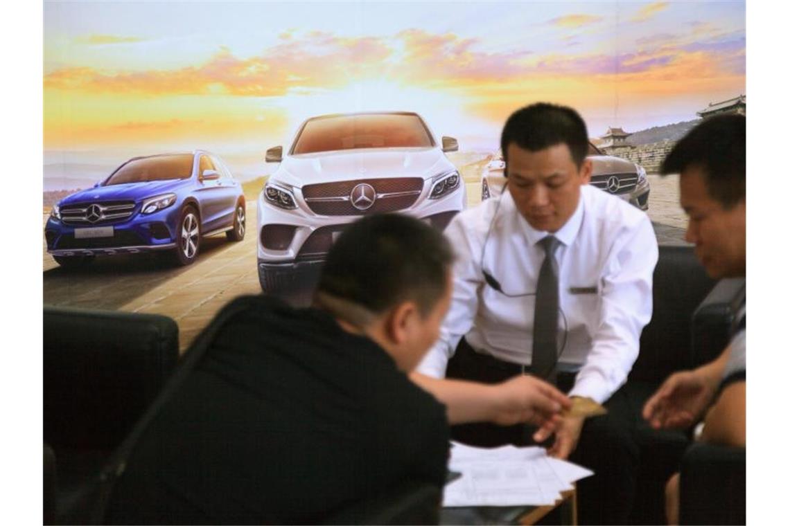 Daimler will führender E-Autobauer werden Autoverkäufer beraten Kunden in einem Autohaus von Mercedes-Benz in der chinesischen Stadt Guangzhou. Foto: Wenjun Chen/dpa