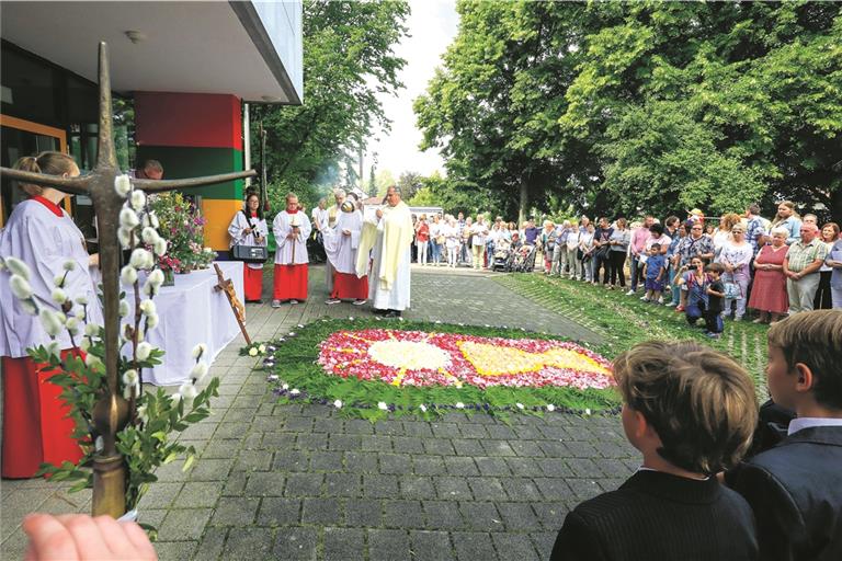 BACKNANG (inf). Die Katholiken haben gestern das Fest Fronleichnam gefeiert, das an das letzte Abendmahl Jesu erinnert und gleichzeitig demonstrieren soll, dass Christus und damit Gott gegenwärtig ist. In Backnang begann die Feier mit einem Gottesdienst in der Christkönigskirche, an den sich eine Prozession zu verschiedenen Blumenteppichen anschloss. Die erste Station bei der Tausschule (Foto) hatte die polnische Gemeinde gestaltet, die beiden weiteren die kroatische Gemeinde und die „Weibsbilder“, eine Gruppe, die auf dem Jakobsweg unterwegs ist. Eine Bläsergruppe begleitete die Prozession. Pfarrer Wolfgang Beck sprach abschließend einen Segen. Im Gemeindehaus Christkönig fand danach ein Gemeindefest mit Verkauf von Töpfereien aus der Töpfergruppe statt. In das Fronleichnamsfest einbezogen wurde auch der gestrige Weltflüchtlingstag. Foto: A. Becher