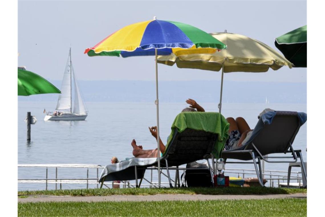 Badegäste liegen am Bodensee. Foto: Felix Kästle/Archivbild