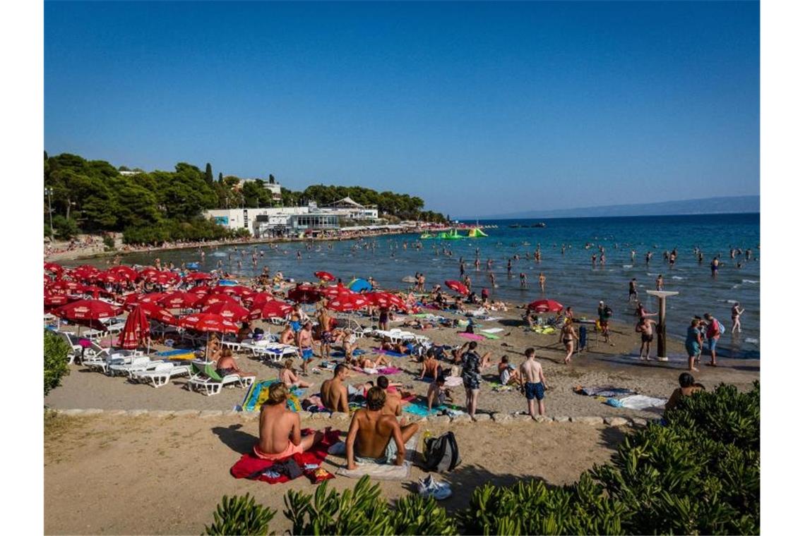 Badegäste sonnen sich am Strand Bacvice. Wegen der gestiegenen Zahl von Corona-Neuinfektionen hat das Auswärtige Amt eine Reisewarnung für Teile des Urlaubslands Kroatien ausgesprochen. Foto: Fernando Gutierrez-Juarez/dpa-Zentralbild/dpa