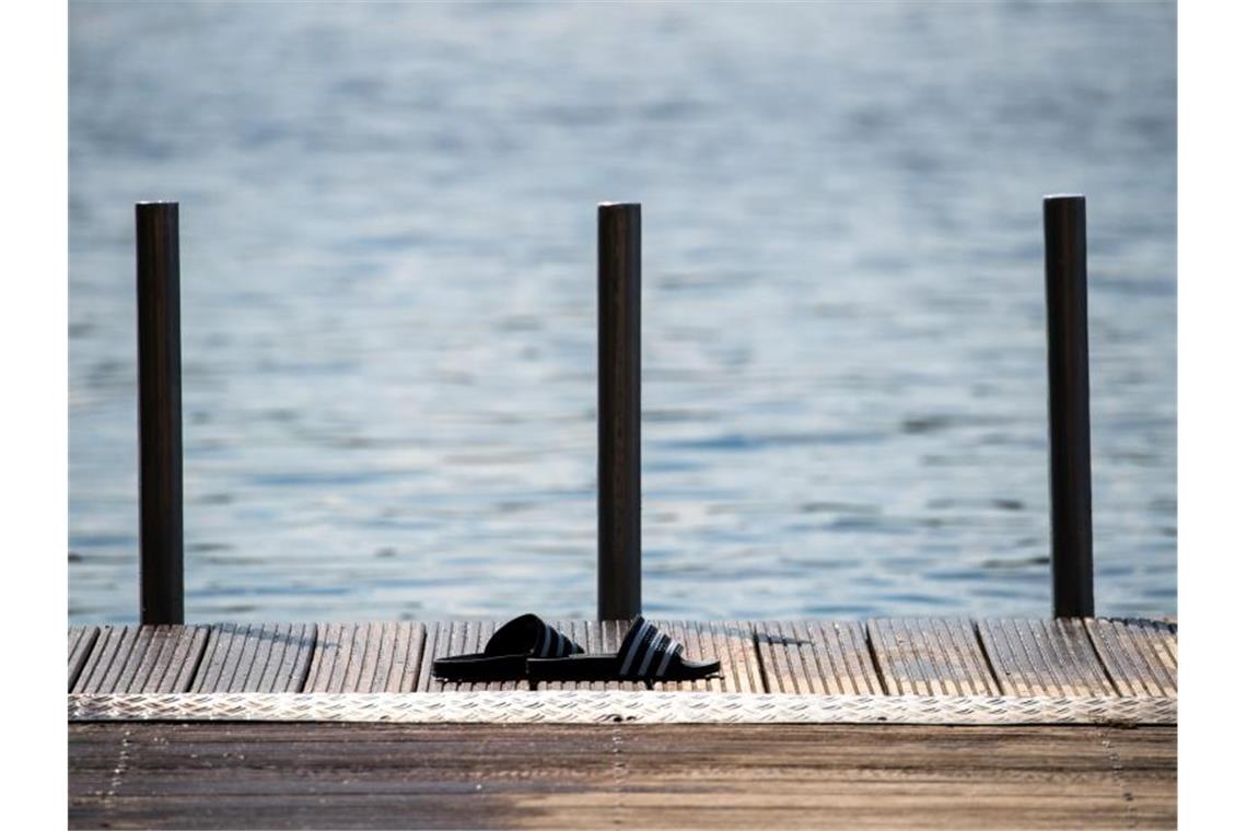 Hitzewarnung für den Osten - Waldbrände in Brandenburg Badeschuhe stehen auf einem Steg am bayrischen Rothsee. Nach einem teils gewittrigen Wochenstart beruhigt sich das Wetter am Dienstag wieder ein wenig. Foto: Daniel Karmann