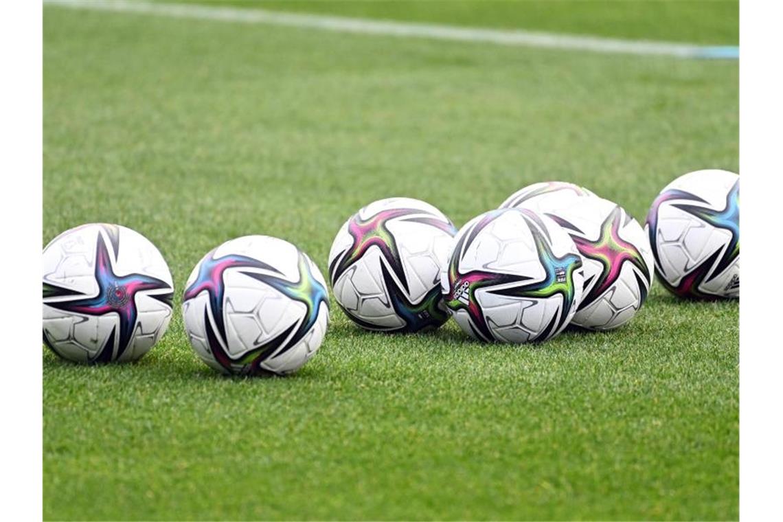 VfB gegen Dortmund unter Flutlicht Bälle liegen auf einem Fußballplatz. Foto: Swen Pförtner/dpa/Symbolbild