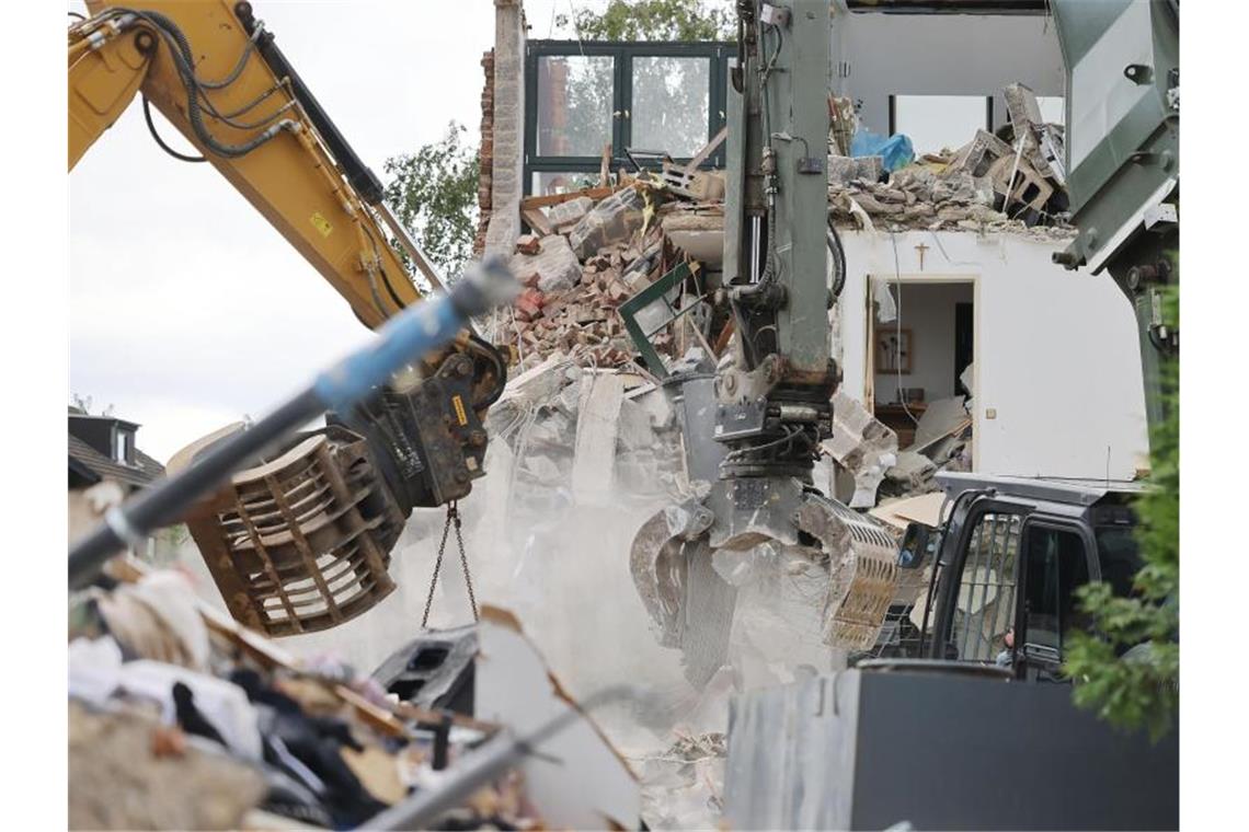 Bagger reißen in Erftstadt-Blessem Häuser ab. Auch drei Wochen nach der Hochwasserkatastrophe ist die Lage nach Einschätzung von Bürgermeisterin Carolin Weitzel dramatisch. Foto: Oliver Berg/dpa