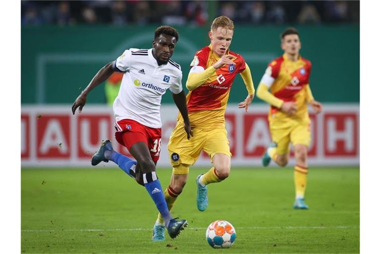 Bakery Jatta (l) vom Hamburger SV und Karlsruhes Tim Breithaupt kämpfen um den Ballbesitz. Foto: Christian Charisius/dpa