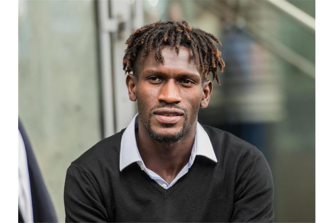 KSC hält sich Protest gegen HSV-Niederlage offen Bakery Jatta sitzt auf dem DFB-Gelände auf einer Mauer zwischen HSV-Vertretern. Foto: Andreas Arnold/Archivbild