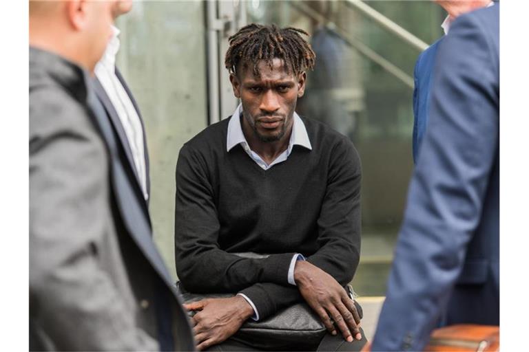 Bakery Jatta vom Hamburger SV sitzt auf dem DFB-Gelände auf einer Mauer zwischen HSV-Vertretern. Foto: Andreas Arnold