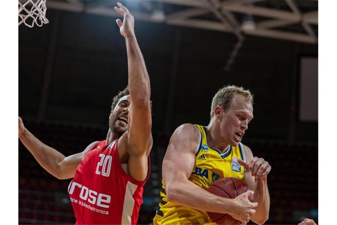 Bambergs Elias Harris (l) in Aktion gegen Luke Sikma von Alba Berlin. Foto: Tilo Wiedensohler/camera4 GbR/BBL/Pool/dpa