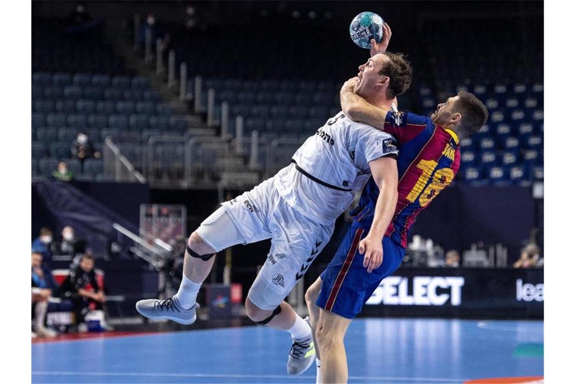 Kiels Handballer triumphieren in der Champions League Barcelonas Blaz Janc (r) foult Kiels Sander Sagosen. Foto: Marius Becker/dpa