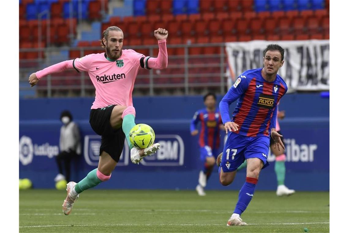 Suárez schießt Atlético in Spaniens Fußball-Himmel Barcelonas Oscar Mingueza (l) im Laufduell mit Eibars Kike Garcia, der den Ball eng am Fuß führt. Foto: Alvaro Barrientos/AP/dpa