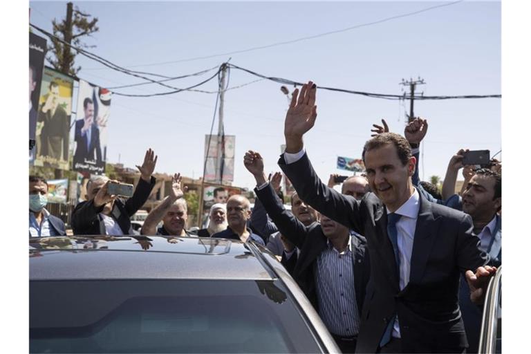 Baschar al-Assad (r), Präsident von Syrien, kommt an einem Wahllokal während der Präsidentschaftswahlen an. Foto: Hassan Ammar/AP/dpa