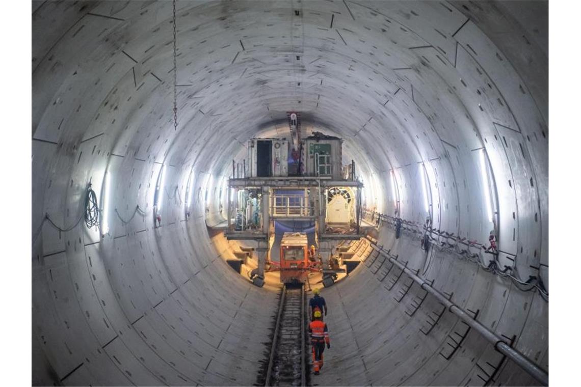 Bauarbeiter laufen durch einen Tunnel. Foto: Tom Weller/dpa/Archivbild