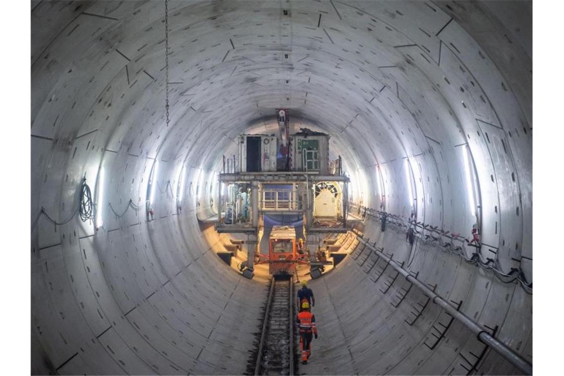 Erste Röhre des Stuttgart 21-Fildertunnels durchgeschlagen Bauarbeiter laufen im Tunnel zu einem Nachläufer der Tunnelbohrmaschine. Foto: Tom Weller/dpa